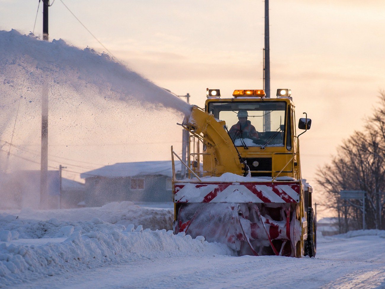 除雪車が朝の道路を除雪する様子(イメージ)