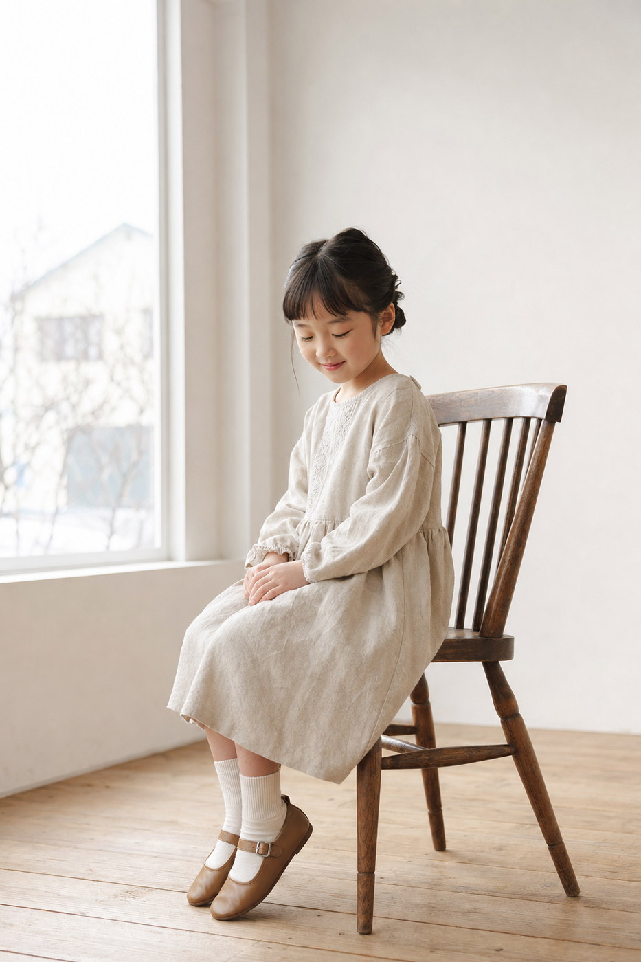 木の椅子に座り膝に手を置く女の子（掲載イメージ）