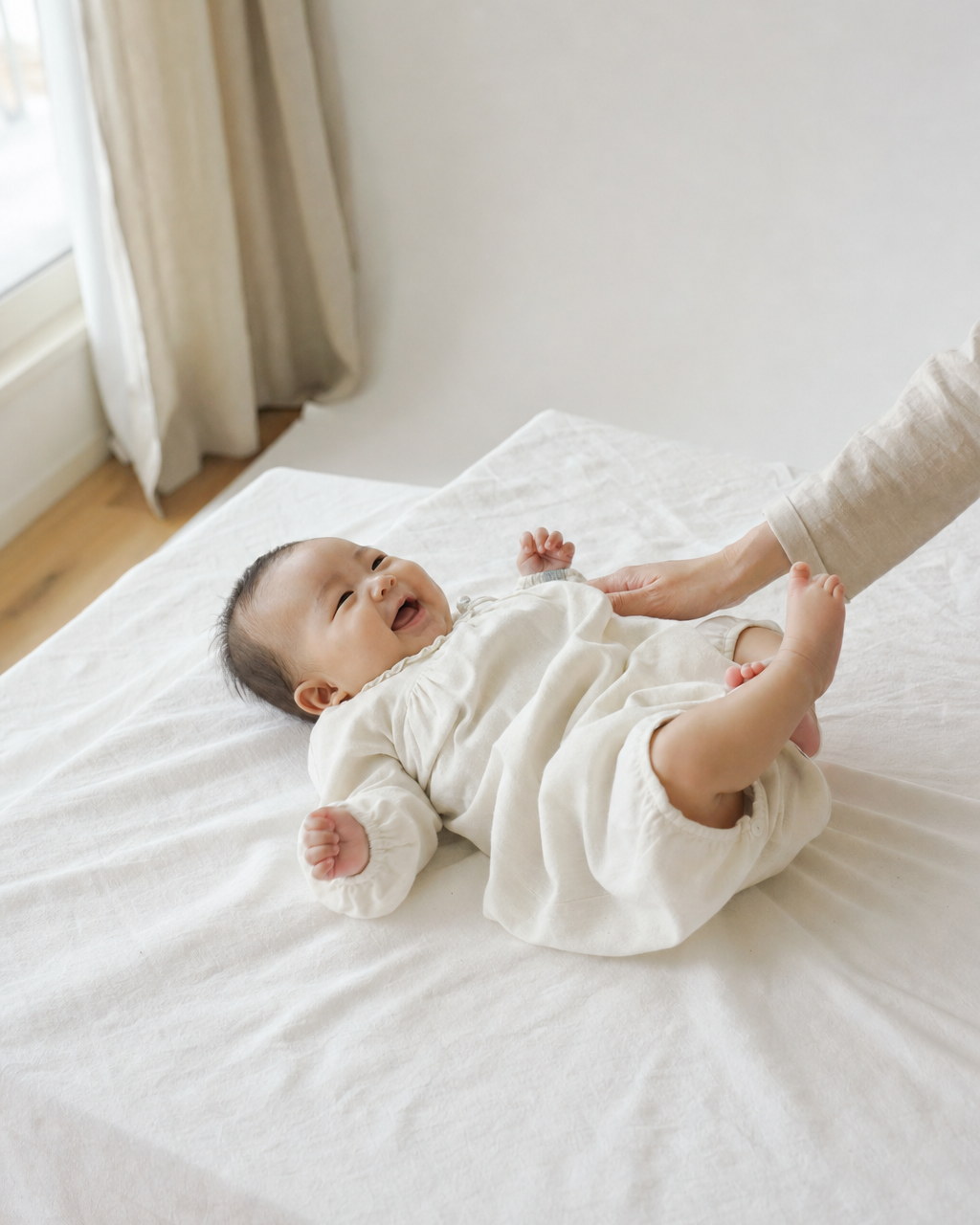 白いシーツの上で手足を動かす赤ちゃん（掲載イメージ）