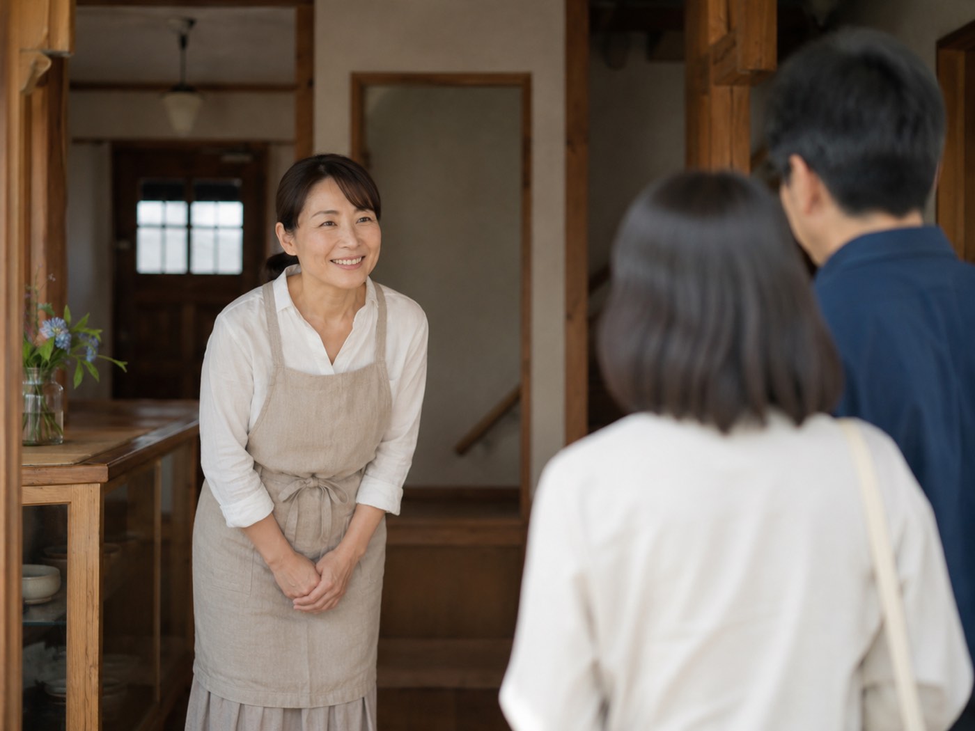 到着したお客様を玄関でお出迎えする女将（架空の人物イメージ）